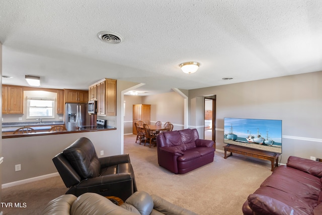 living room with light carpet, a textured ceiling, and sink