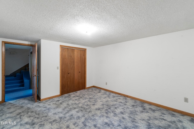 unfurnished bedroom featuring a closet, carpet, and a textured ceiling