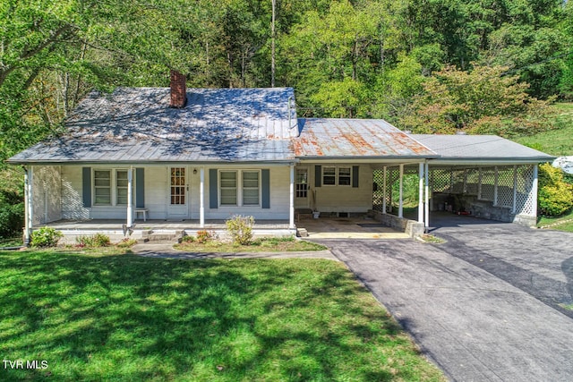 farmhouse featuring a front yard, a porch, and a carport