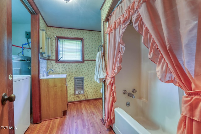 bathroom featuring washer / clothes dryer, vanity, washtub / shower combination, crown molding, and hardwood / wood-style floors