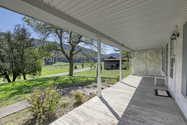 wooden terrace featuring a lawn