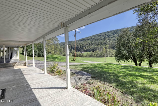 wooden terrace with a mountain view and a yard