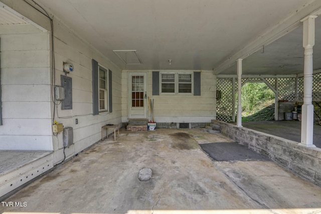 view of patio featuring electric panel and a carport