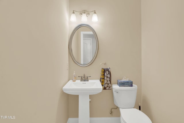 bathroom with baseboards and toilet