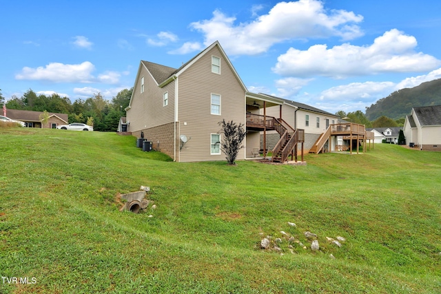 rear view of house featuring central AC, a lawn, stairway, and a wooden deck