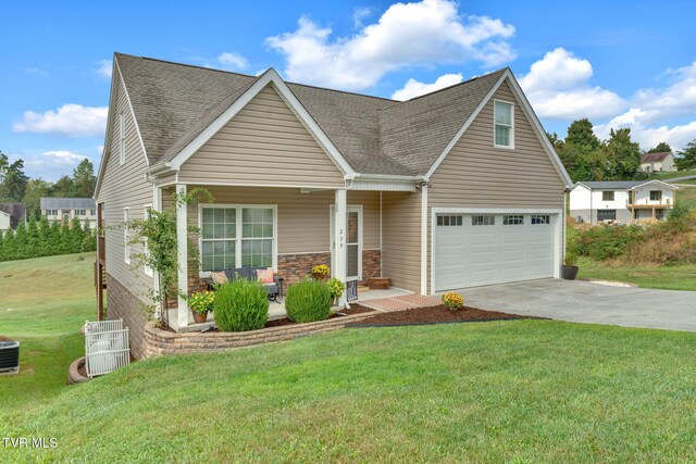 view of front of property featuring roof with shingles, covered porch, a garage, driveway, and a front lawn