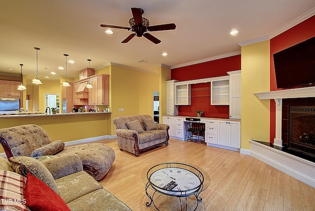 living room featuring built in desk, light hardwood / wood-style floors, and crown molding