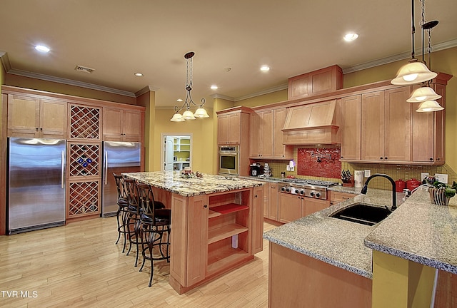 kitchen with sink, appliances with stainless steel finishes, custom range hood, a center island, and light hardwood / wood-style floors