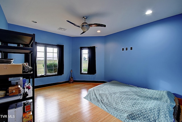 bedroom with light hardwood / wood-style floors and ceiling fan