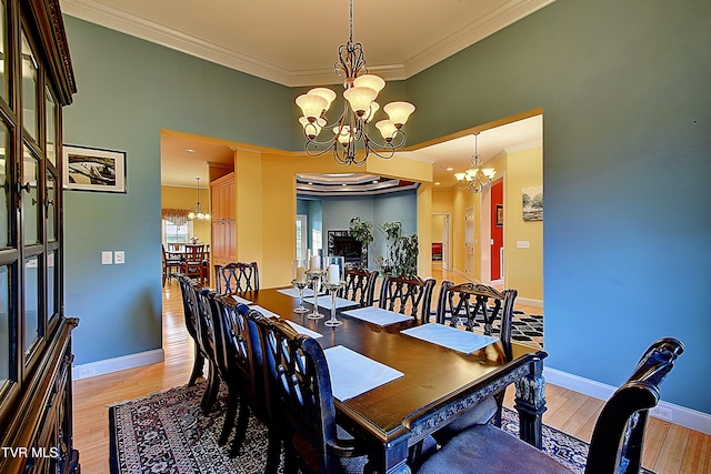 dining space with light hardwood / wood-style flooring, a chandelier, and crown molding