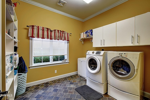 laundry area featuring crown molding, washing machine and clothes dryer, and cabinets