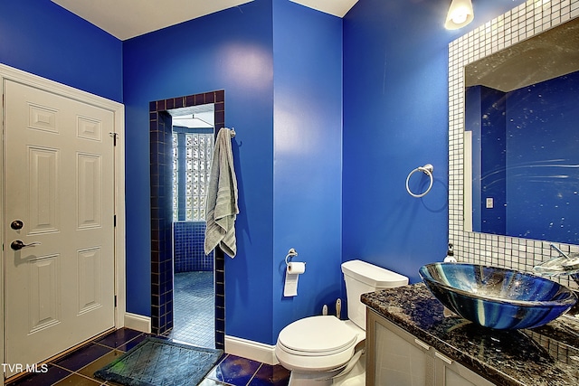 bathroom featuring tiled shower, vanity, toilet, and tile patterned floors