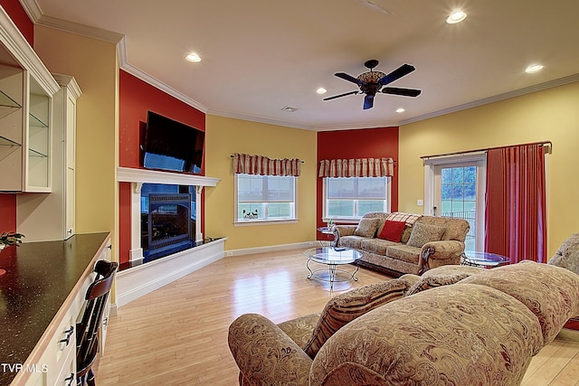 living room featuring light hardwood / wood-style floors, ornamental molding, and ceiling fan