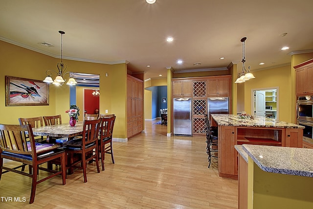 dining room featuring light wood-type flooring, a chandelier, and crown molding