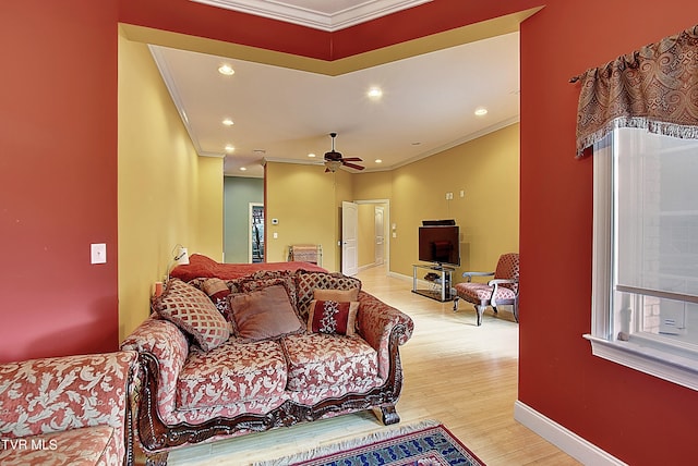 living room featuring light hardwood / wood-style flooring, ceiling fan, and crown molding