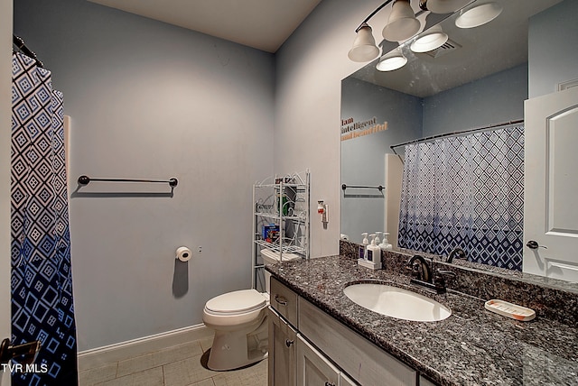 bathroom with tile patterned flooring, vanity, and toilet