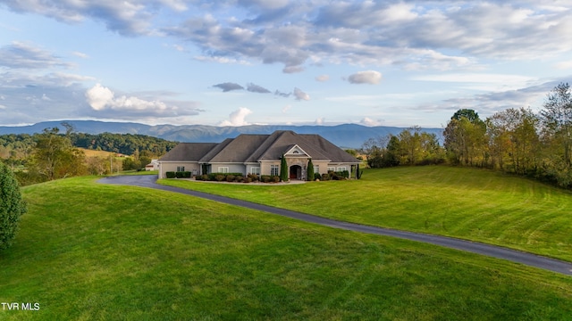 ranch-style house featuring a mountain view and a front yard