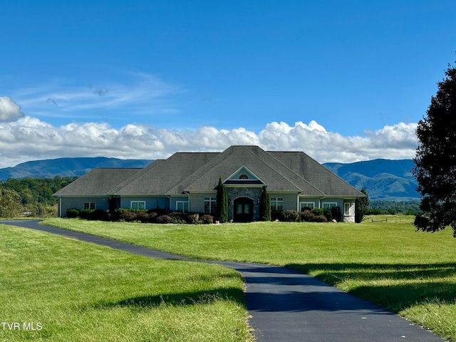 ranch-style house featuring a front lawn and a mountain view