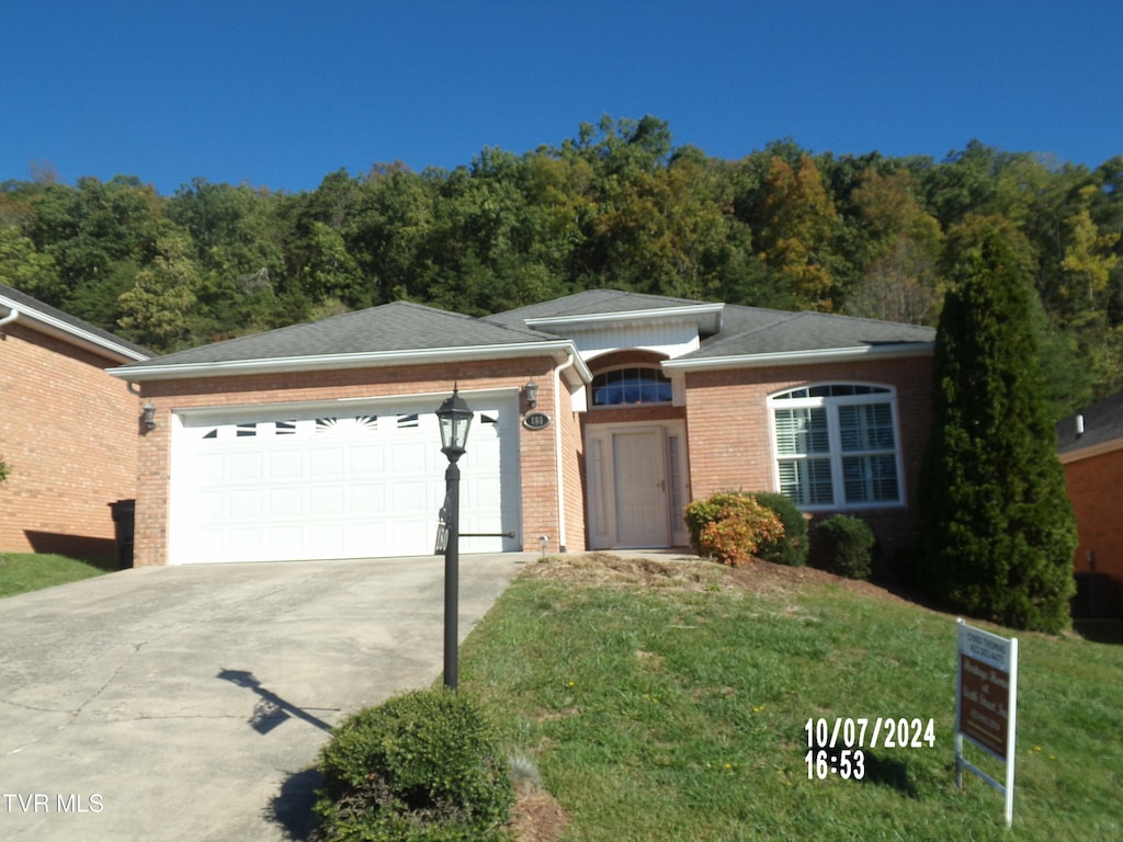 view of front of home with a garage and a front lawn