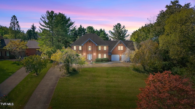 view of front of home with a garage and a yard