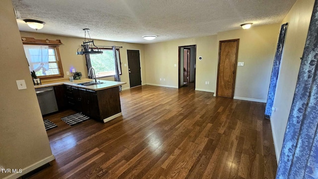 kitchen featuring dishwasher, dark wood-type flooring, sink, and kitchen peninsula