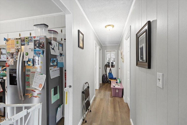 hallway with hardwood / wood-style flooring, crown molding, and wood walls