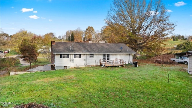 rear view of property featuring a yard and a deck