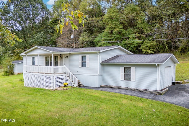 view of front of house with a garage, a front lawn, and covered porch