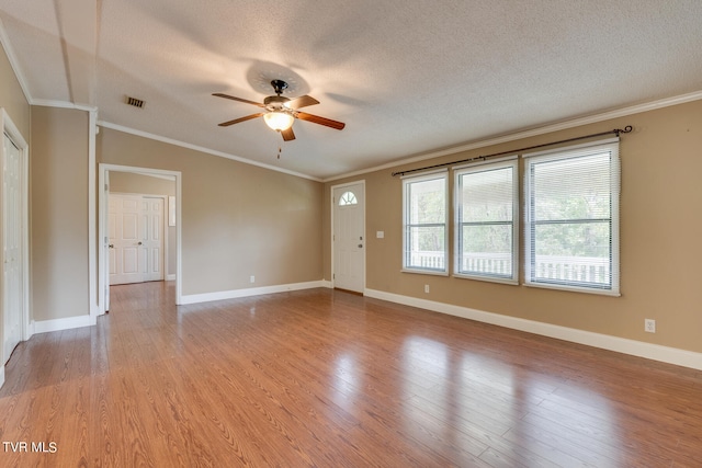 spare room featuring ceiling fan, a textured ceiling, light hardwood / wood-style flooring, and ornamental molding