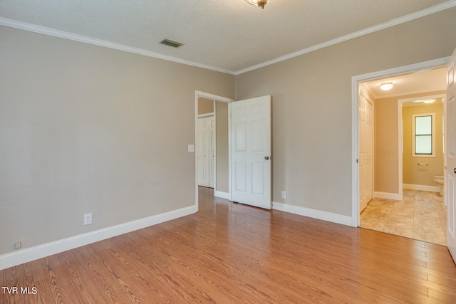 unfurnished room featuring a textured ceiling, crown molding, and light hardwood / wood-style floors