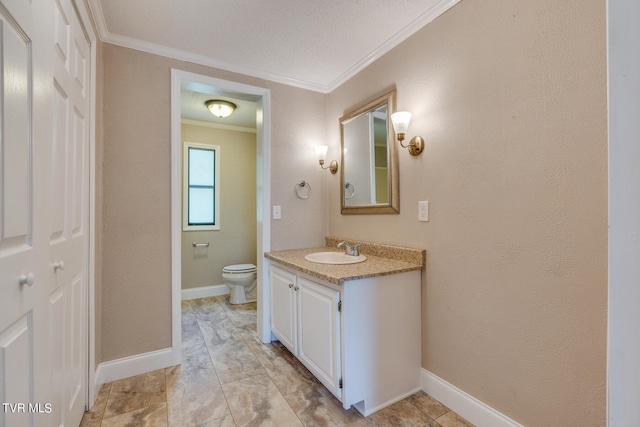 bathroom with vanity, crown molding, and toilet