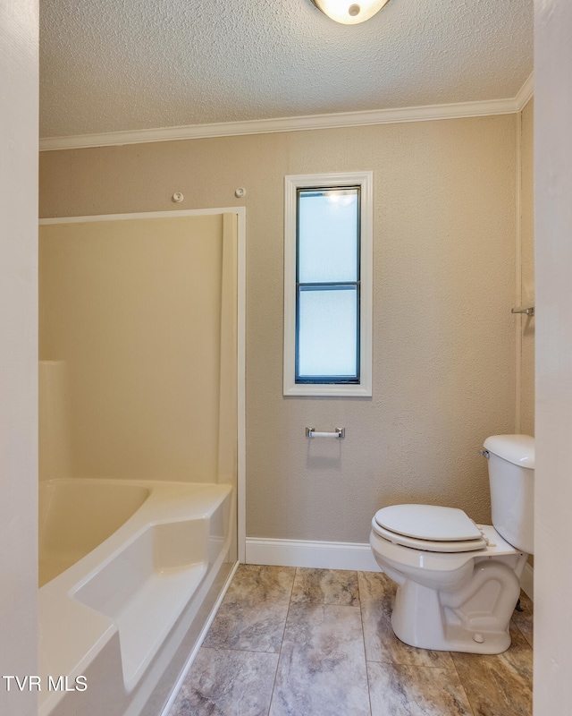 bathroom featuring tile patterned flooring, a textured ceiling, a tub to relax in, crown molding, and toilet