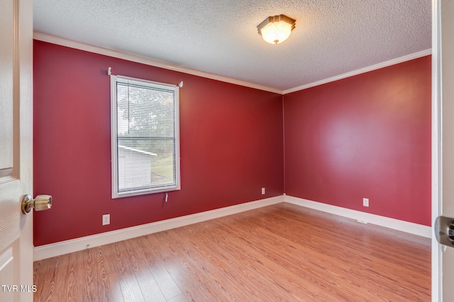 spare room featuring ornamental molding, a textured ceiling, and hardwood / wood-style floors