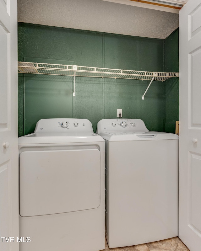 washroom featuring a textured ceiling and washing machine and clothes dryer