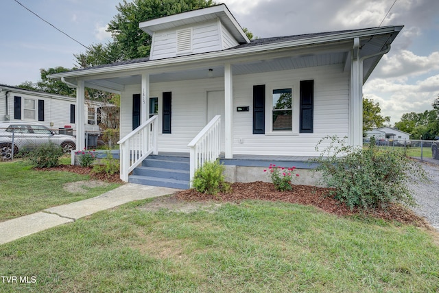 bungalow with a front yard and covered porch