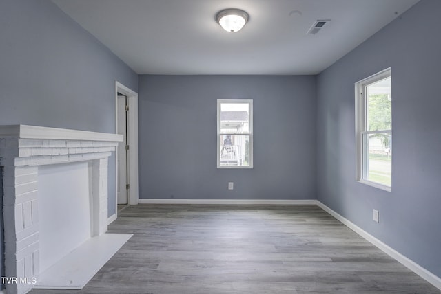 unfurnished living room with light wood-type flooring and plenty of natural light