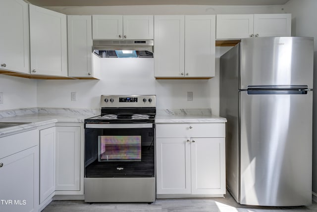 kitchen with light stone countertops, appliances with stainless steel finishes, light hardwood / wood-style flooring, and white cabinetry