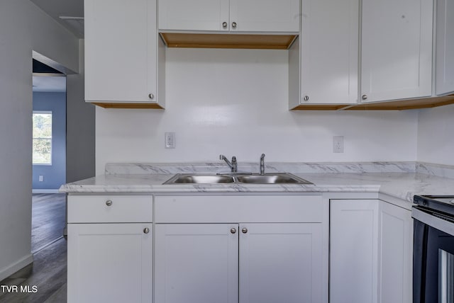 kitchen with light stone counters, sink, stainless steel electric range, white cabinetry, and dark hardwood / wood-style flooring