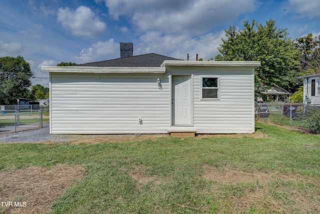 rear view of house featuring a lawn