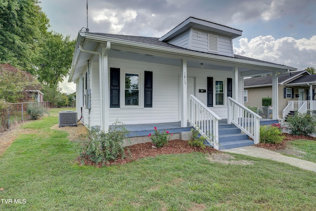 bungalow-style house with a porch, a front lawn, and central AC unit