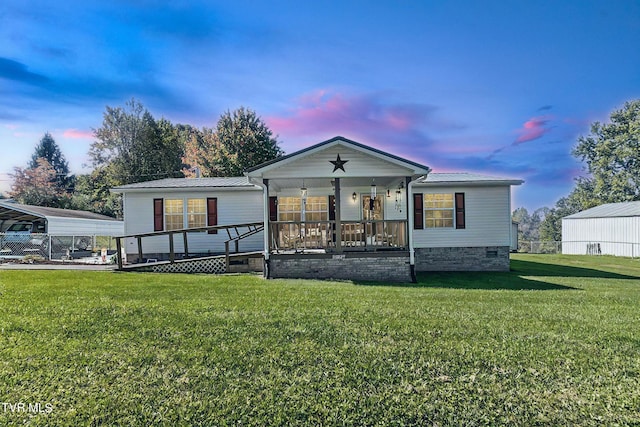 view of front of house featuring a carport, a porch, and a yard