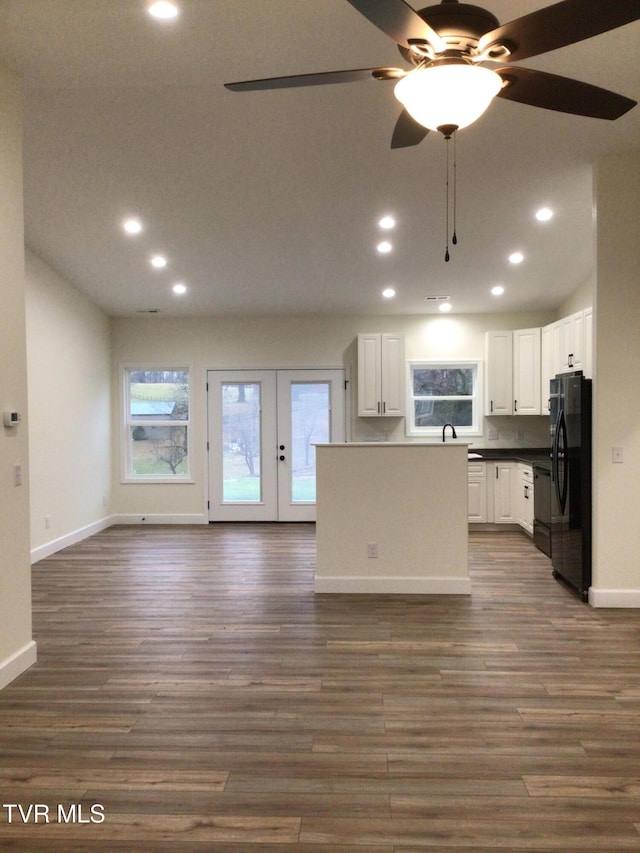 kitchen featuring white cabinets, dark hardwood / wood-style flooring, black fridge, and ceiling fan