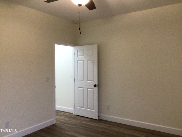 empty room with dark hardwood / wood-style flooring and ceiling fan