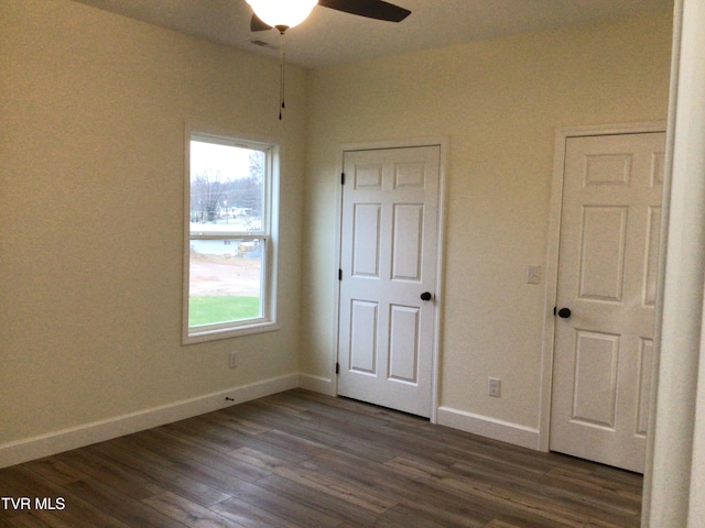 unfurnished bedroom featuring ceiling fan and dark hardwood / wood-style floors