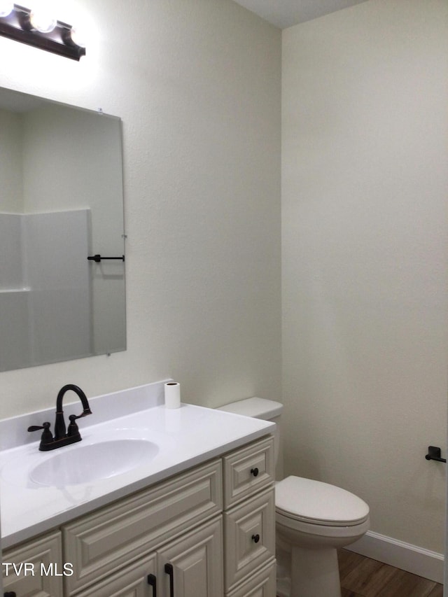 bathroom featuring vanity, hardwood / wood-style flooring, and toilet