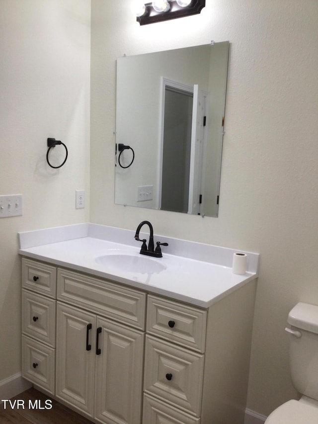 bathroom with vanity, toilet, and wood-type flooring