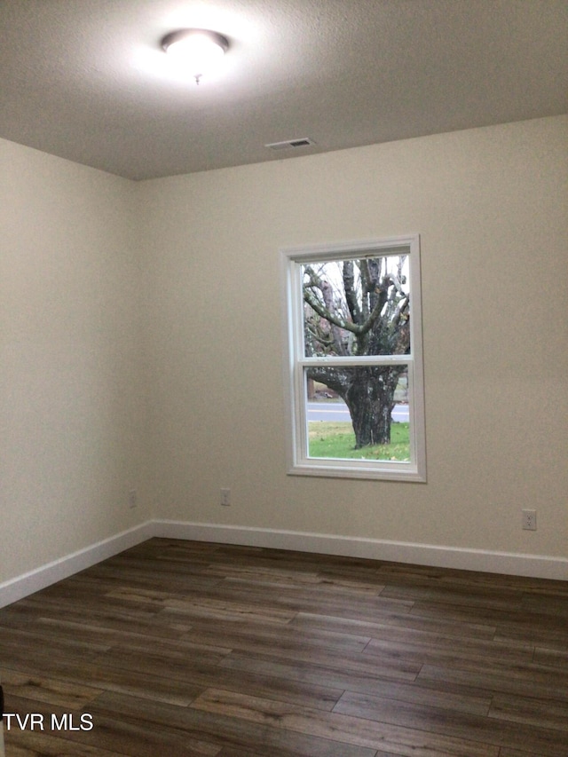 unfurnished room with dark wood-type flooring