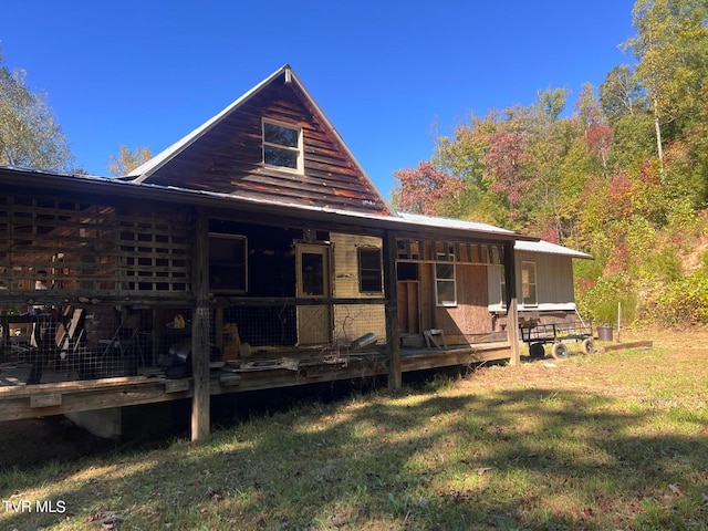 back of property with a yard and a wooden deck