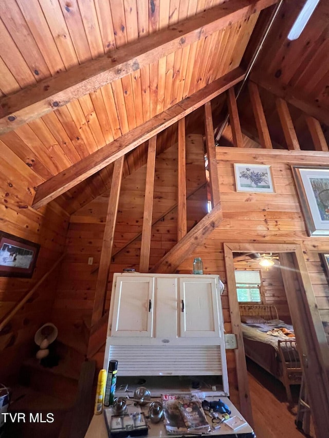 interior space featuring wooden walls, lofted ceiling with beams, and wood ceiling