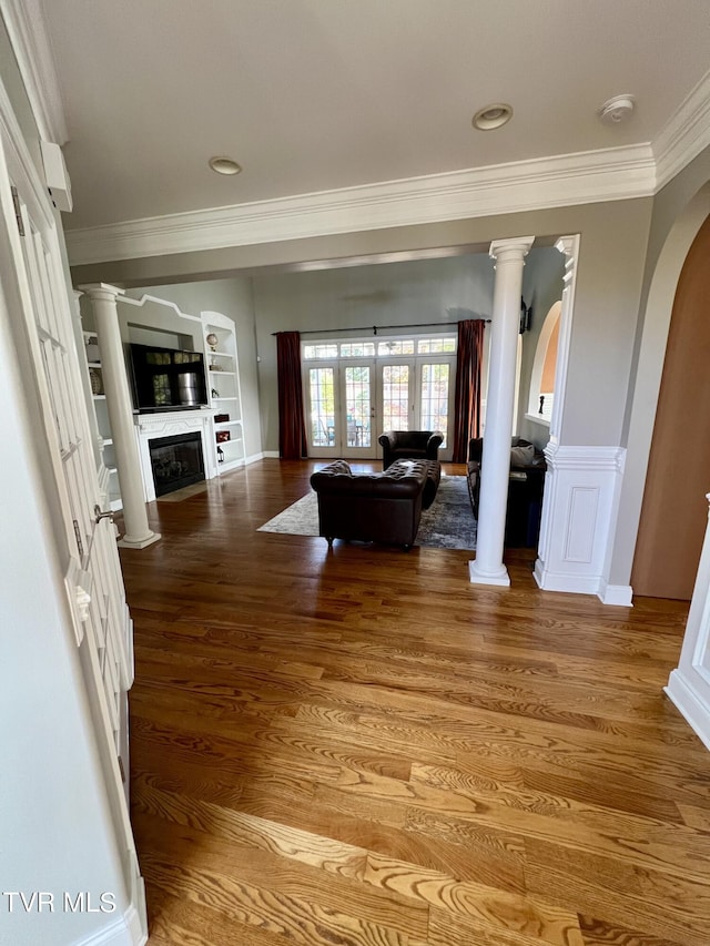 living room featuring french doors, hardwood / wood-style flooring, ornamental molding, and built in shelves